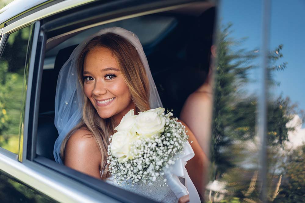 Mladenka s buketom u automobilu - fotografije vjenčanja